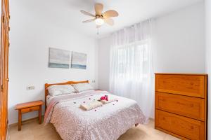 a bedroom with a bed with a ceiling fan and a dresser at Good Atmosphere in Orihuela +15 photos