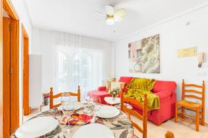 a living room with a red couch and a table at Good Atmosphere in Orihuela