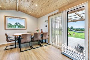 a dining room with a table and chairs and a sliding glass door at Naturpur Tinyhouse in Osterrade