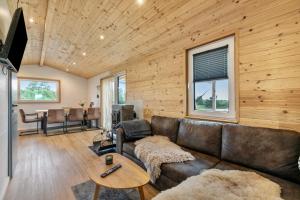 a living room with a leather couch and a table at Naturpur Tinyhouse in Osterrade