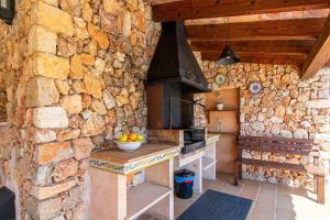 a kitchen with a stone wall with a stove at Hortet in Campos