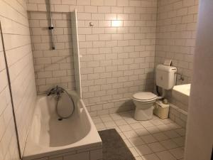 a bathroom with a tub and a toilet and a sink at La Passerelle de la Doller in Reiningue