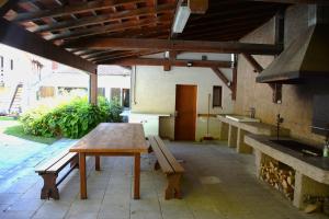 a patio with a wooden table and a bench at La Passerelle de la Doller in Reiningue