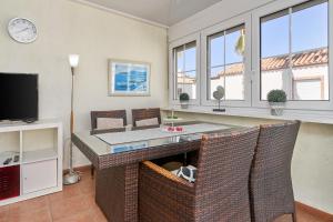 a living room with a table and chairs and a tv at Casa Cox Laguna Beach Torrox Costa in Torrox Costa