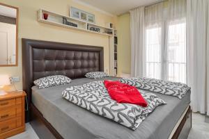 a bedroom with a large bed with a red pillow at Casa Cox Laguna Beach Torrox Costa in Torrox Costa +19 photos