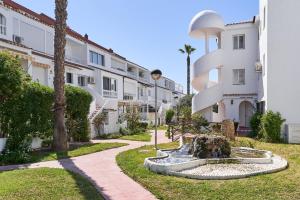 a courtyard with a fountain in front of a building at Casa Cox Laguna Beach Torrox Costa in Torrox Costa
