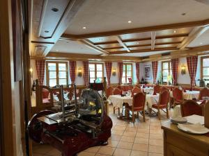 a restaurant with tables and chairs and a machine at Hotel Rusticone Hechendorf in Seefeld