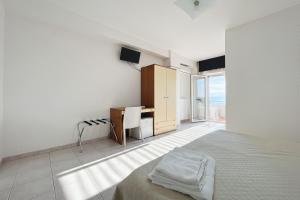 a bedroom with a bed and a desk in it at Santangelo in Monte SantʼAngelo