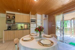 a kitchen with a table with plates and flowers on it at Maison Chloé - Mas Lachamp in Gravières