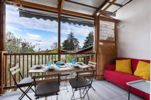 a balcony with a table and chairs and a red couch at Haus am Gardasee mit Seeblick in Raffa