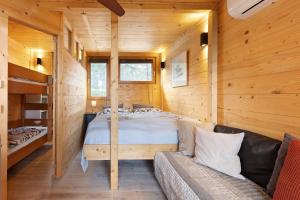 a bedroom in a log cabin with a bed and a couch at Haus am Gardasee mit Seeblick in Raffa