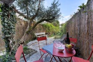 a red table and chairs with a bottle of wine at Haus am Gardasee mit Seeblick in Raffa