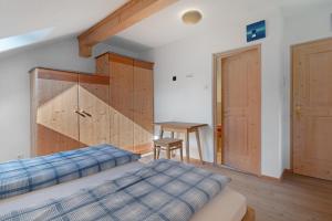 a bedroom with a bed and a table and a desk at Rielingerhof in Collalbo