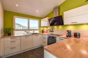 a kitchen with green walls and a wooden counter top at Ferienwohnung zum Krummholz in Fischerbach