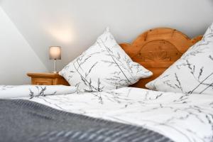 a bedroom with a bed with white sheets and pillows at Ferienwohnung zum Krummholz in Fischerbach