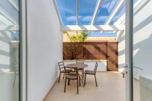 a room with a table and chairs on a balcony at Casa Don Paolo in Alessano