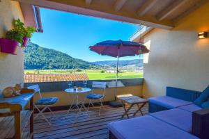 a patio with a table and an umbrella at Ferienwohnung zum Krummholz in Fischerbach