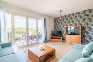 a living room with a couch and a television at Ferrera Soul 1b in Santanyi