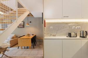 a kitchen with white cabinets and a wooden table at Orange Apartments A in Porto