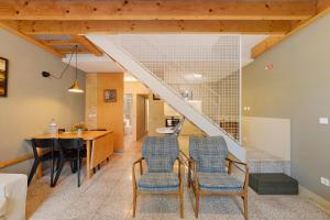 a living room with a table and chairs and a staircase at Orange Apartments A in Porto