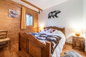 a bedroom with a bed in a log cabin at Appart Cosy 3 étoiles in Arâches-la-Frasse