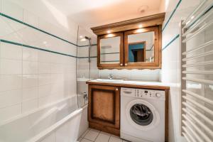 a bathroom with a washing machine and a sink at Appart Cosy 3 étoiles in Arâches-la-Frasse