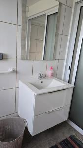 a bathroom with a white sink and a mirror at Baía do Porto das Lajes in Lajes das Flores +21 photos
