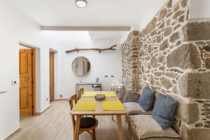 a living room with a table and a stone wall at El Blanquizal A in San Nicolás