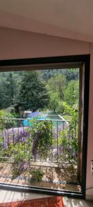a window view of a garden with purple flowers at Au fil de l'eau in Chambonas