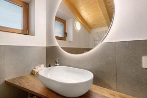 a bathroom with a white sink and a mirror at Villa Helena - Panorama Dolomiti in Cavalese +37 photos
