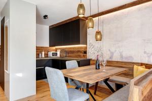a kitchen and dining room with a wooden table and chairs at Villa Helena - Panorama Dolomiti in Cavalese