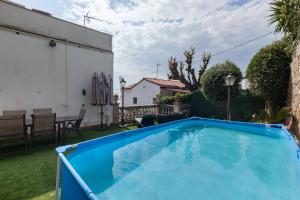 a large blue swimming pool in a yard at Bruc Apartment Beach in Canet de Mar