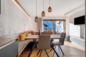a kitchen and dining room with a wooden table and chairs at Villa Helena - Panorama Dolomiti in Cavalese