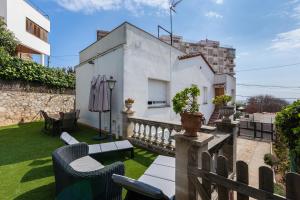 a balcony with chairs and a fence and a building at Bruc Apartment Beach in Canet de Mar