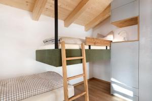 two bunk beds in a small room with a ladder at Villa Helena - Panorama Dolomiti in Cavalese