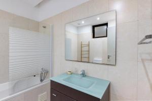 a bathroom with a sink and a mirror and a tub at T2 Furadouro 30m from the beach in Ovar +13 photos