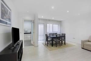 a living room with a table and chairs and a television at T2 Furadouro 30m from the beach in Ovar