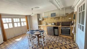 a kitchen with a table and chairs in it at Sous Le Tilleul - 3 personnes in Valréas