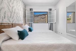 a bedroom with a large bed with two windows at Mangueros Suite 18 Puerto de Mogán in Puerto de Mogán +17 photos