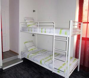 two bunk beds in a room with green accents at L'appart Millau Centre-Ville - Gite in Millau