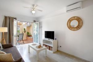 a living room with a couch and a tv at Mangueros Suite 18 Puerto de Mogán in Puerto de Mogán