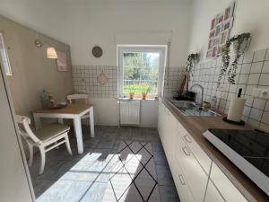 a kitchen with a sink and a table and a window at Am Conradhof 2 in Goch