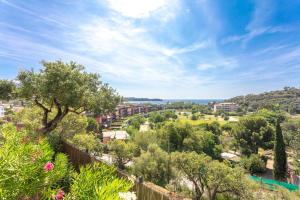 a view of a town with trees and the ocean at Le Plein Sud Terrasse vue mer Agay in Saint-Raphaël