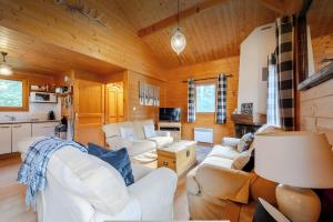 a living room with white furniture and wooden walls at Chalet Chocolat - 10 pers - Châtel in Châtel