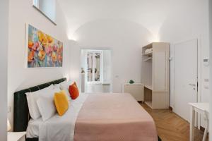a white bedroom with a large bed with orange pillows at Lubrense Signature Suites in Massa Lubrense