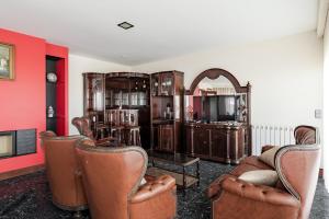 a living room with leather furniture and a mirror at Casa Do Chino in Esposende