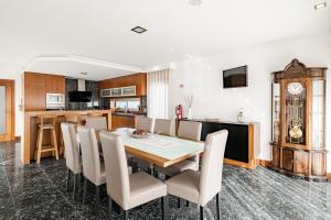 a dining room with a table and chairs and a clock at Casa Do Chino in Esposende