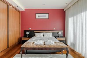 a bedroom with a red wall and a bed at Casa Do Chino in Esposende +21 photos
