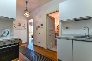 a kitchen with white cabinets and a sink at Elba Offsite Villa in Capoliveri