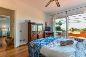 a bedroom with a bed and a large window at Elba Offsite Villa in Capoliveri +37 photos